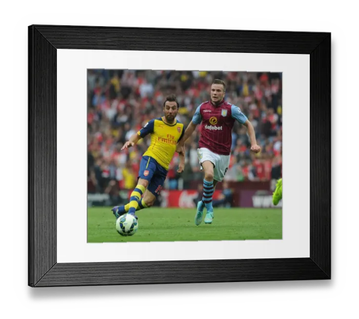 Framed Print : Santi Cazorla vs Tom Cleverley: Intense Battle in Aston Villa vs Arsenal Premier League Clash