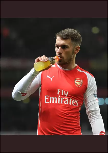 Aaron Ramsey Fueling Up: Arsenal's Star Player Sips Gatorade Before Kickoff Against Manchester United in Emirates Stadium