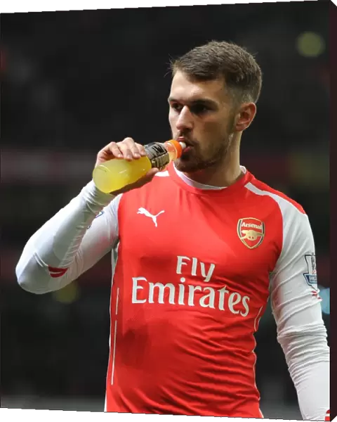 Aaron Ramsey Fueling Up: Arsenal's Star Player Sips Gatorade Before Kickoff Against Manchester United in Emirates Stadium