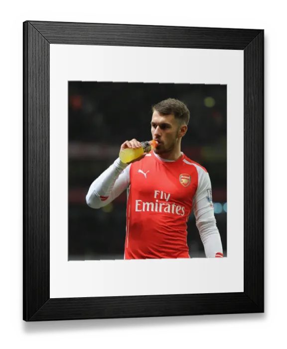Framed Print : Aaron Ramsey Fueling Up: Arsenal's Star Player Sips Gatorade Before Kickoff Against Manchester United in Emirates Stadium