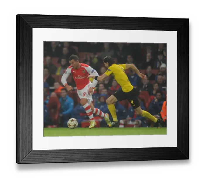 Framed Print : Arsenal's Podolski Clashes with Dortmund's Subotic in Champions League Showdown