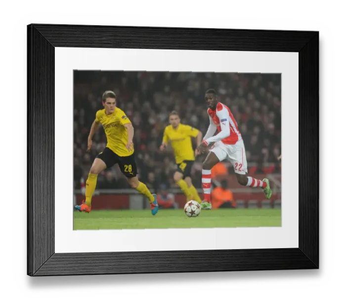Framed Print : Arsenal's Yaya Sanogo Faces Off Against Borussia Dortmund's Matthias Ginter in Champions League Clash Framed Print : Arsenal's Yaya Sanogo Faces Off Against Borussia Dortmund's Matthias Ginter in Champions League Clash