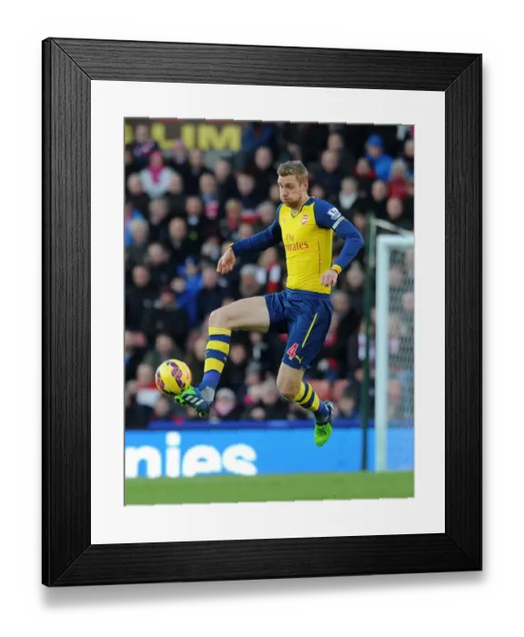 Framed Print : Per Mertesacker Focuses in Stoke City vs Arsenal Premier League Clash (2014-15)