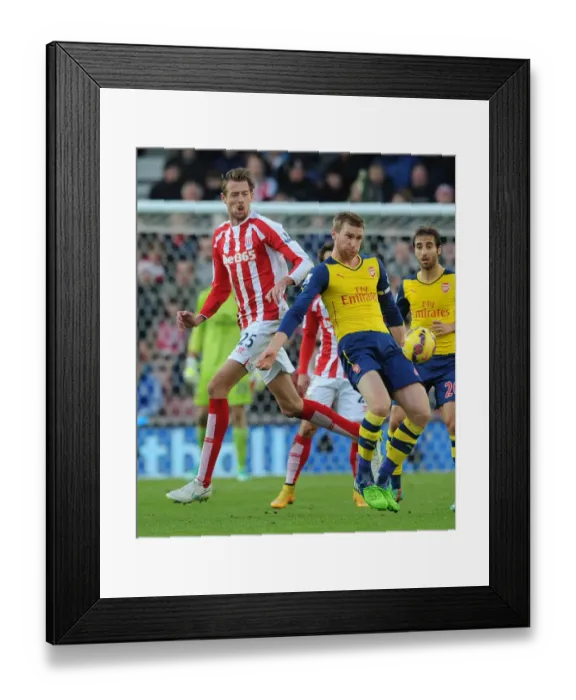 Framed Print : Per Mertesacker Fends Off Peter Crouch in Intense Stoke City vs. Arsenal Clash