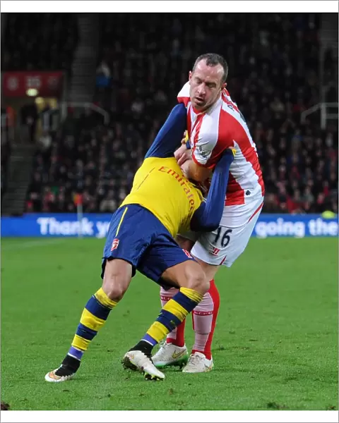 STOKE ON TRENT, ENGLAND - DECEMBER 06: Alexis Sanchez of Arsenal is fouled by Charlie