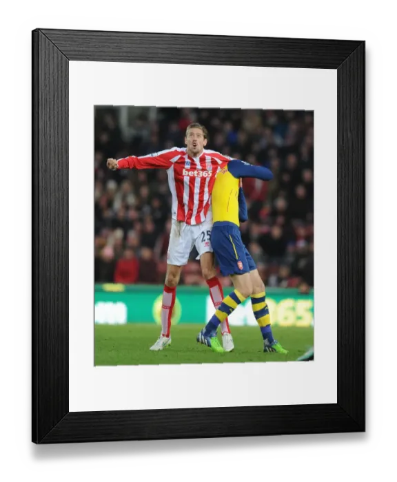 Framed Print : Clash of Titans: Mertesacker vs. Crouch - Stoke City vs. Arsenal, Premier League Framed Print : Clash of Titans: Mertesacker vs. Crouch - Stoke City vs. Arsenal, Premier League