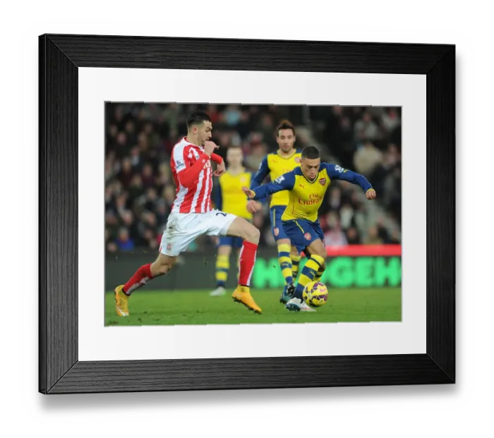 Framed Print : Arsenal's Alex Oxlade-Chamberlain Fends Off Stoke's Erik Pieters during Premier League Clash Framed Print : Arsenal's Alex Oxlade-Chamberlain Fends Off Stoke's Erik Pieters during Premier League Clash