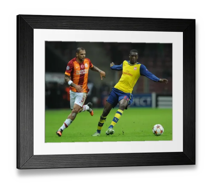 Framed Print : Arsenal's Ramsey Outmaneuvers Galatasaray's Melo in Champions League Clash Framed Print : Arsenal's Ramsey Outmaneuvers Galatasaray's Melo in Champions League Clash