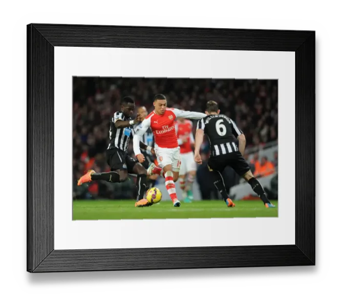 Framed Print : Arsenal's Oxlade-Chamberlain Faces Off Against Newcastle's Tiote and Williamson in Intense Clash