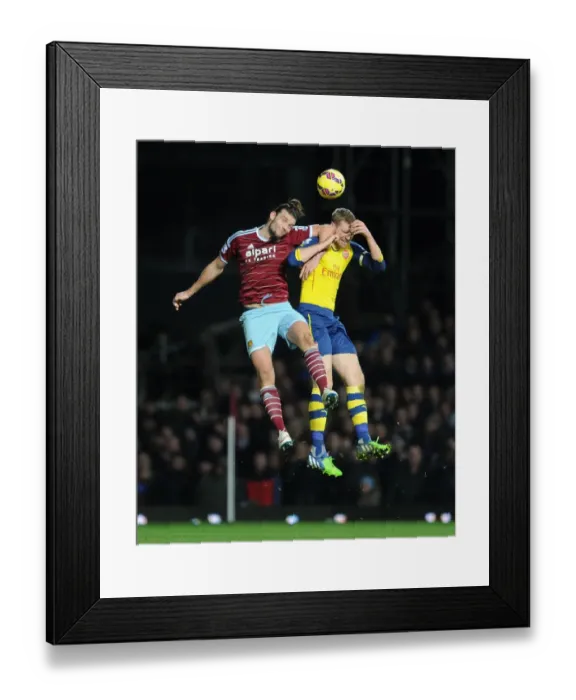 Framed Print : Per Mertesacker vs. Andy Carroll: Intense Clash in West Ham United vs. Arsenal Premier League Match Framed Print : Per Mertesacker vs. Andy Carroll: Intense Clash in West Ham United vs. Arsenal Premier League Match