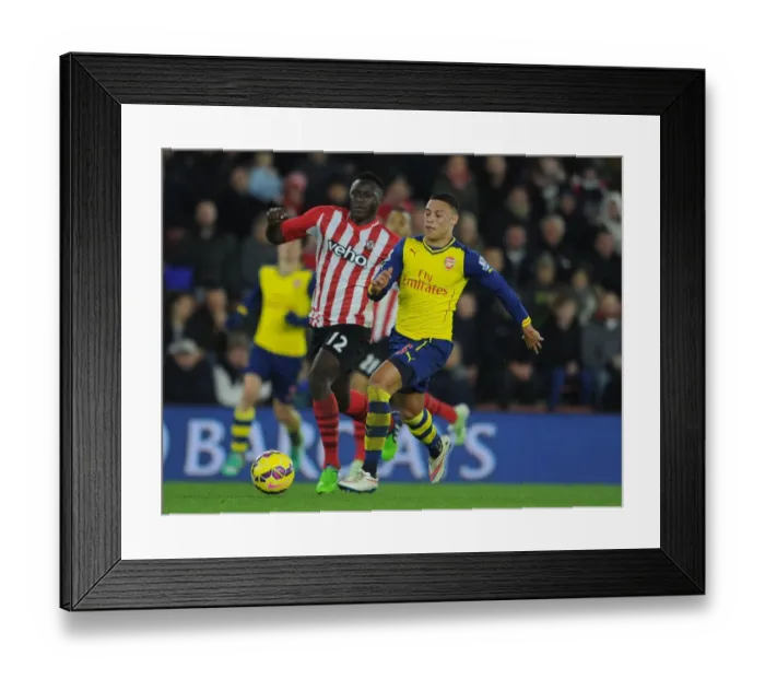 Framed Print : Arsenal's Oxlade-Chamberlain Clashes with Southampton's Wanyama in Premier League Showdown (January 2015)
