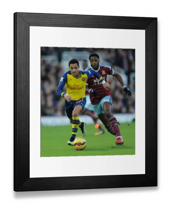 Framed Print : Arsenal's Alexis Sanchez Breaks Past West Ham's Alex Song in Premier League Clash (December 2014)