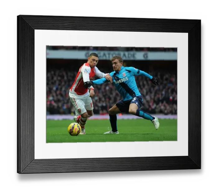 Framed Print : Arsenal's Oxlade-Chamberlain Faces Off Against Stoke's Muniesa in Premier League Clash