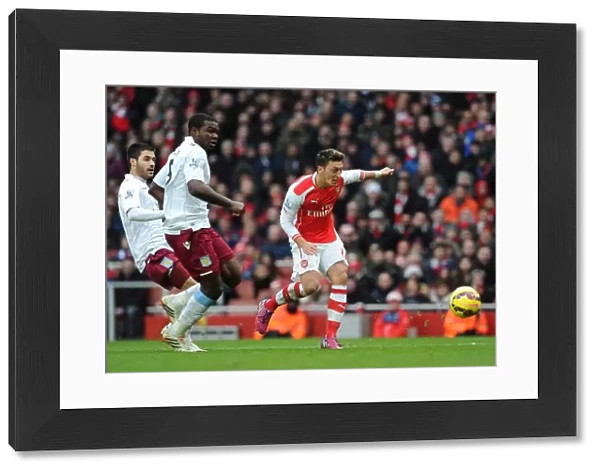 Mesut Ozil scores Arsenals 2nd goal under pressure from Jores Okore and Carles Gil (Villa)