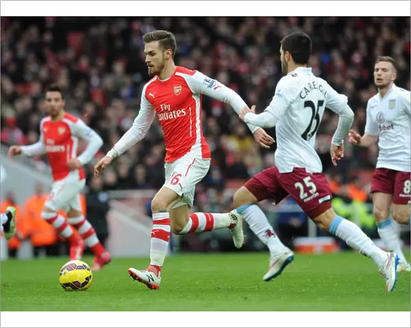 Arsenal's Aaron Ramsey Faces Off Against Aston Villa's Carles Gil in Intense Premier League Clash