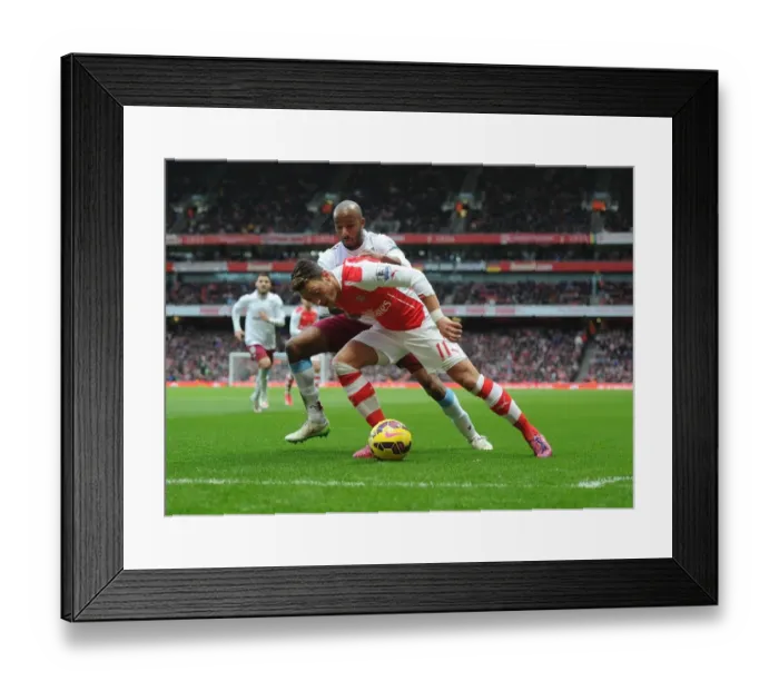 Framed Print : Mesut Ozil vs Fabian Delph: Intense Battle at Arsenal's Emirates Stadium (Arsenal v Aston Villa, 2014-15)