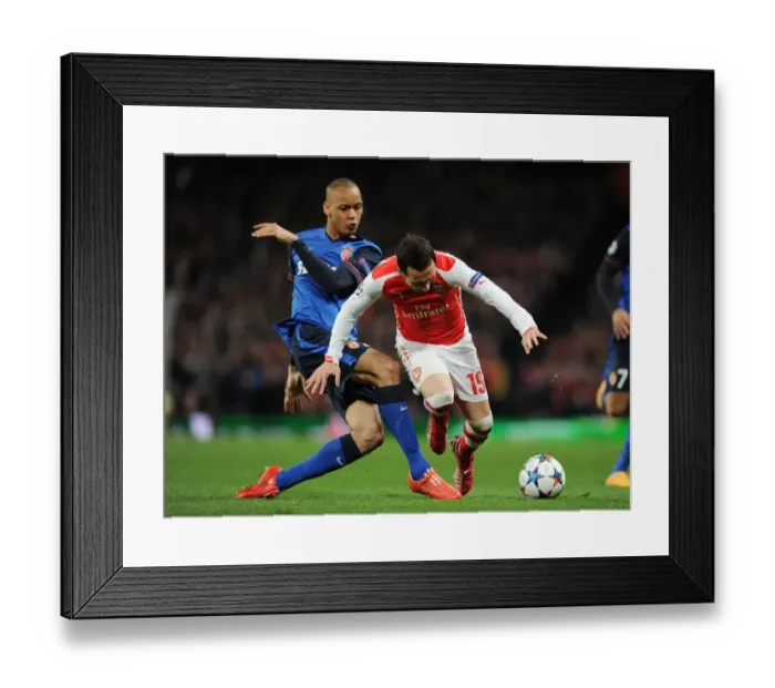 Framed Print : Clash of Midfield Maestros: Santi Cazorla vs Fabinho in Arsenal's UEFA Champions League Battle against AS Monaco