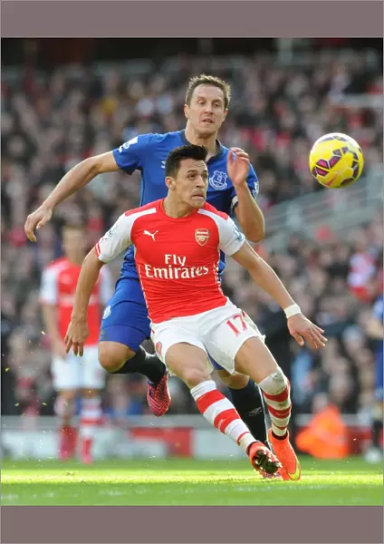 Arsenal's Alexis Sanchez Fends Off Everton's Phil Jagielka in Intense Premier League Clash