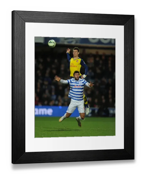 Framed Print : Arsenal's Laurent Koscielny Soars Above QPR's Charlie Austin in Premier League Clash