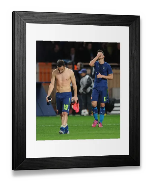 Framed Print : Departing Duo: Ozil and Cazorla Leave the Field after Monaco vs. Arsenal UEFA Champions League Clash