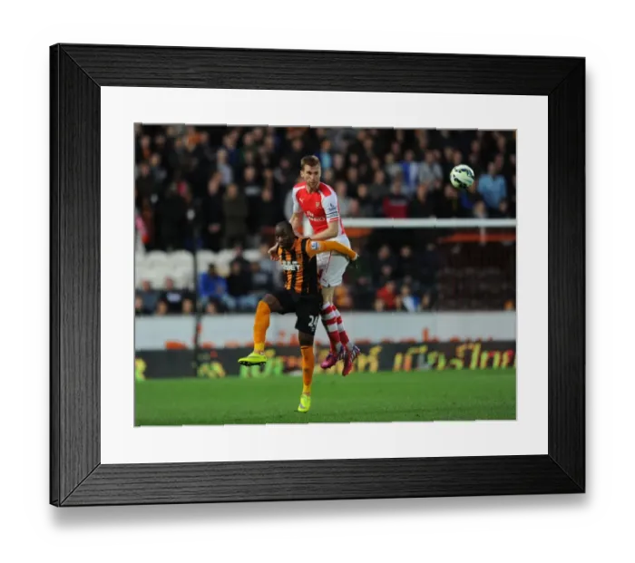 Framed Print : Mertesacker Defends: Arsenal Star Heads Away Hull's Aluko in Intense Premier League Clash