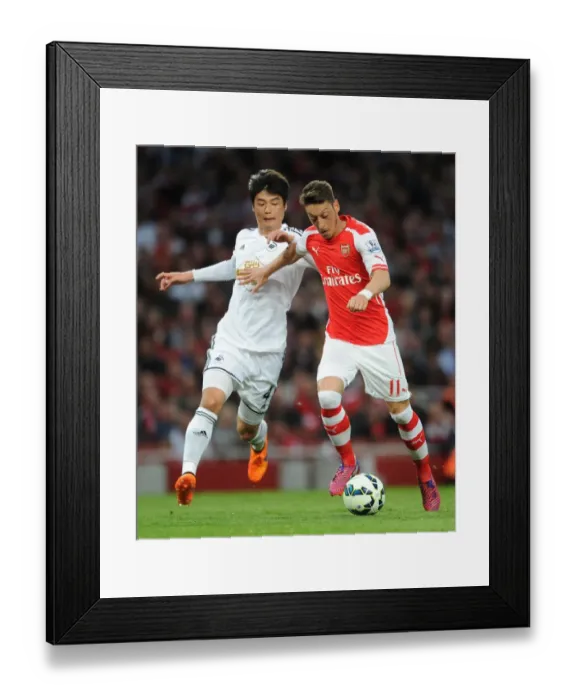 Framed Print : Mesut Ozil vs. Ki Sung-Yueng: A Premier League Battle at Emirates Stadium (2014 / 15) Framed Print : Mesut Ozil vs. Ki Sung-Yueng: A Premier League Battle at Emirates Stadium (2014 / 15)