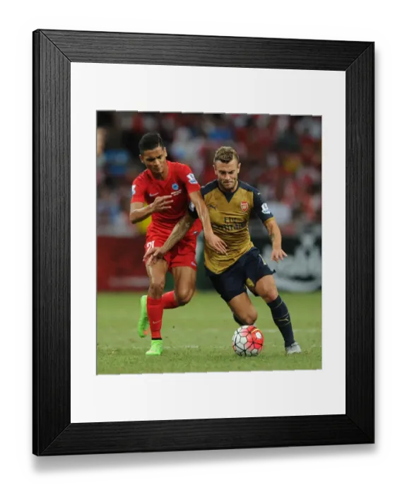 Framed Print : Arsenal's Jack Wilshere Fends Off Singapore XI's Safuwan Baharudin During Barclays Asia Trophy Match Framed Print : Arsenal's Jack Wilshere Fends Off Singapore XI's Safuwan Baharudin During Barclays Asia Trophy Match