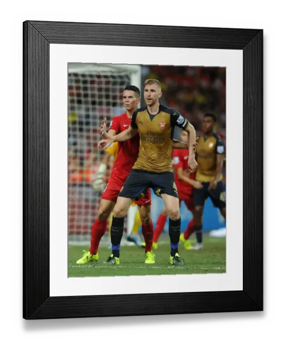 Framed Print : Arsenal's Per Mertesacker Fends Off Opponent in Barclays Asia Trophy Clash vs Singapore (July 15, 2015)