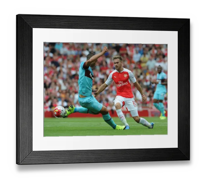 Framed Print : Ramsey Stands Firm: Arsenal's Midfielder Fends Off West Ham's Reid in Intense Premier League Showdown