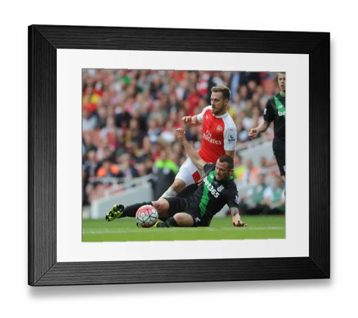 Framed Print : Arsenal's Aaron Ramsey Faces Off Against Phil Bardsley in Intense Premier League Clash Framed Print : Arsenal's Aaron Ramsey Faces Off Against Phil Bardsley in Intense Premier League Clash