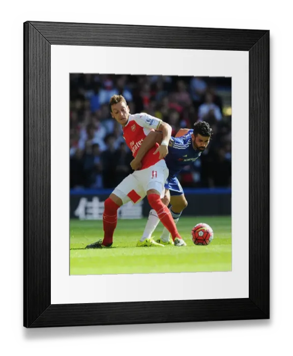 Framed Print : Clash of Titans: Ozil vs Costa - Premier League Showdown: A Battle Between Arsenal's Ozil and Chelsea's Costa