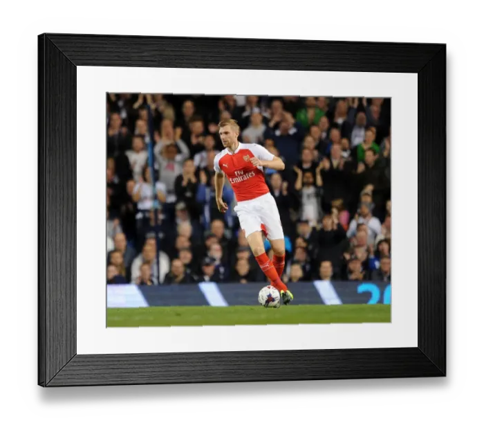 Framed Print : Per Mertesacker's Intense Focus: Arsenal vs. Tottenham Capital One Cup Showdown