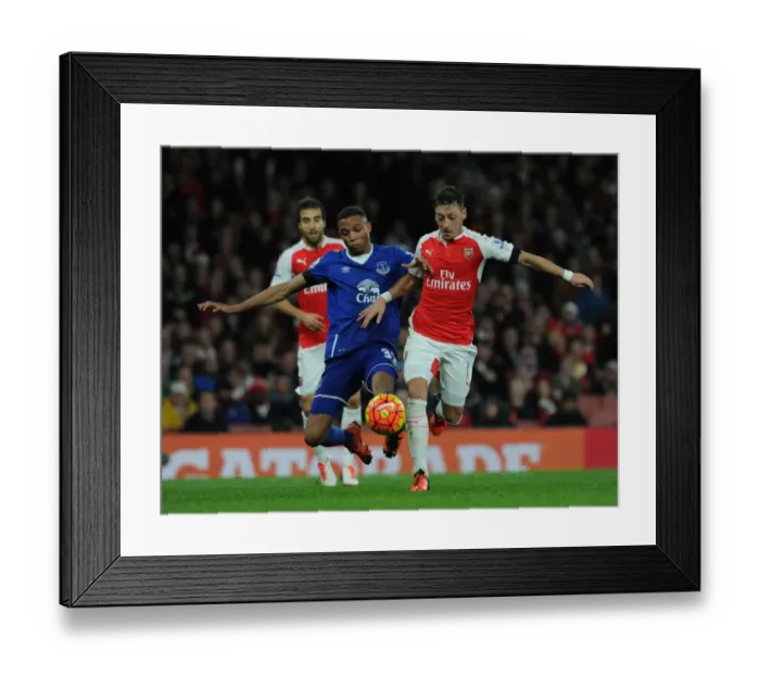 Framed Print : Ozil vs. Galloway: A Premier League Battle at Emirates Stadium