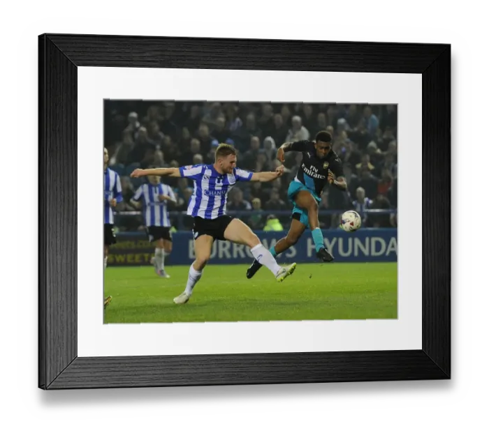 Framed Print : Arsenal's Alex Iwobi vs. Tom Lees: A Fierce Face-Off in the Capital One Cup Clash Framed Print : Arsenal's Alex Iwobi vs. Tom Lees: A Fierce Face-Off in the Capital One Cup Clash