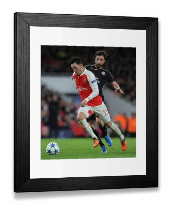 Framed Print : Mesut Ozil Escapes Past Goncalo Santos: Arsenal's Thrilling Chase in the UEFA Champions League vs. Dinamo Zagreb, 2015