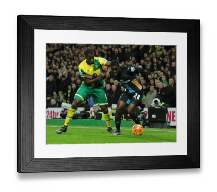 Framed Print : Arsenal's Joel Campbell Fends Off Norwich Defender During Intense Premier League Showdown