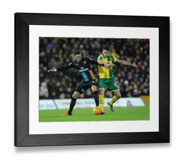 Framed Print : Intense Rivalry: Mesut Ozil vs. Robbie Brady Clash in Norwich City vs. Arsenal Premier League Match