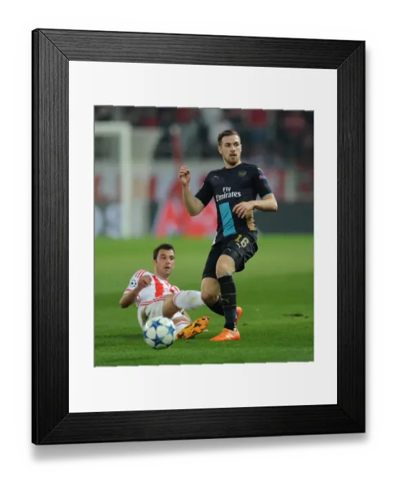 Framed Print : Ramsey vs Milivojevic: A Battle for Ball Possession in Olympiacos vs Arsenal UEFA Champions League Clash