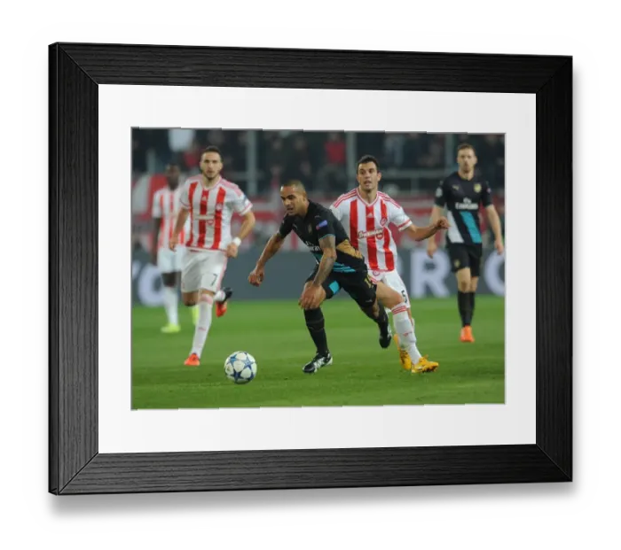 Framed Print : Theo Walcott vs. Luka Milivojevic: A Battle in the UEFA Champions League
