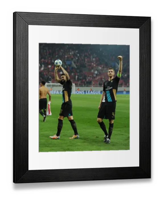 Framed Print : Arsenal's Victory Celebration: Giroud and Mertesacker Embrace after Winning against Olympiacos
