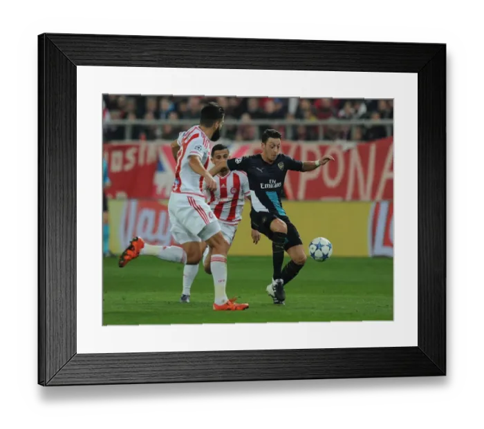 Framed Print : Mesut Ozil Outmaneuvers Dimitris Siovas: A Thrilling Moment from Arsenal's UEFA Champions League Clash with Olympiacos (December 2015)