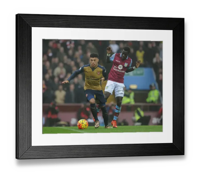 Framed Print : Arsenal's Alex Oxlade-Chamberlain vs. Aston Villa's Idrissa Gana: Intense Battle on the Premier League Field Framed Print : Arsenal's Alex Oxlade-Chamberlain vs. Aston Villa's Idrissa Gana: Intense Battle on the Premier League Field