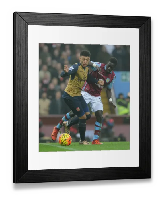 Framed Print : Arsenal's Alex Oxlade-Chamberlain vs. Idrissa Gana: Intense Battle in Aston Villa vs. Arsenal Premier League Clash Framed Print : Arsenal's Alex Oxlade-Chamberlain vs. Idrissa Gana: Intense Battle in Aston Villa vs. Arsenal Premier League Clash