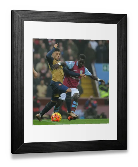 Framed Print : Arsenal's Alex Oxlade-Chamberlain vs. Idrissa Gana: Intense Battle in Aston Villa vs. Arsenal Premier League Clash Framed Print : Arsenal's Alex Oxlade-Chamberlain vs. Idrissa Gana: Intense Battle in Aston Villa vs. Arsenal Premier League Clash