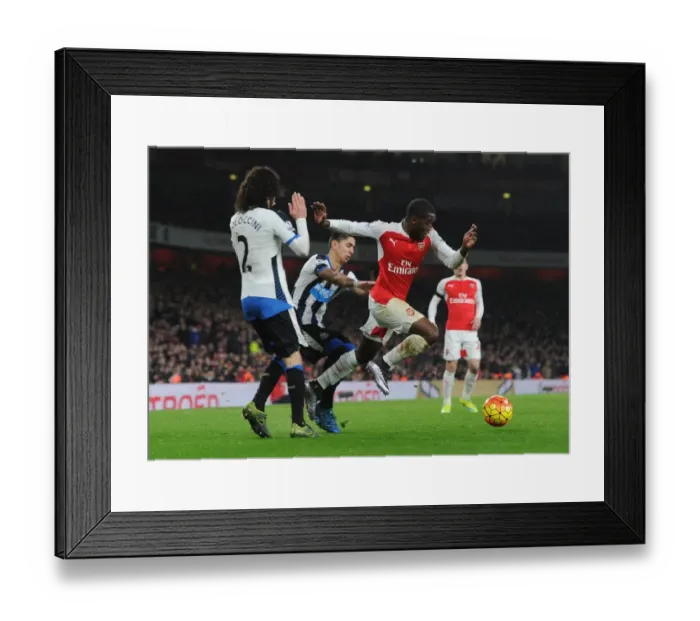 Framed Print : Arsenal's Joel Campbell Faces Off Against Newcastle's Coloccini and Perez During Intense Premier League Clash Framed Print : Arsenal's Joel Campbell Faces Off Against Newcastle's Coloccini and Perez During Intense Premier League Clash
