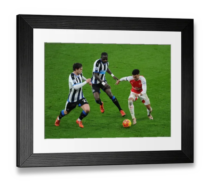Framed Print : Arsenal's Oxlade-Chamberlain Stands Firm Against Newcastle's Janmaat and Sissoko