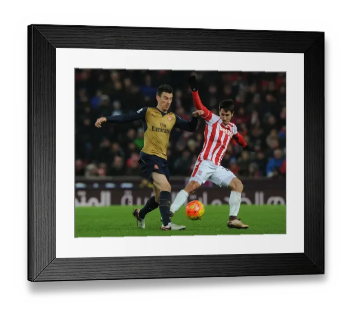 Framed Print : Arsenal's Koscielny Goes Head-to-Head with Stoke's Bojan in Intense Premier League Showdown