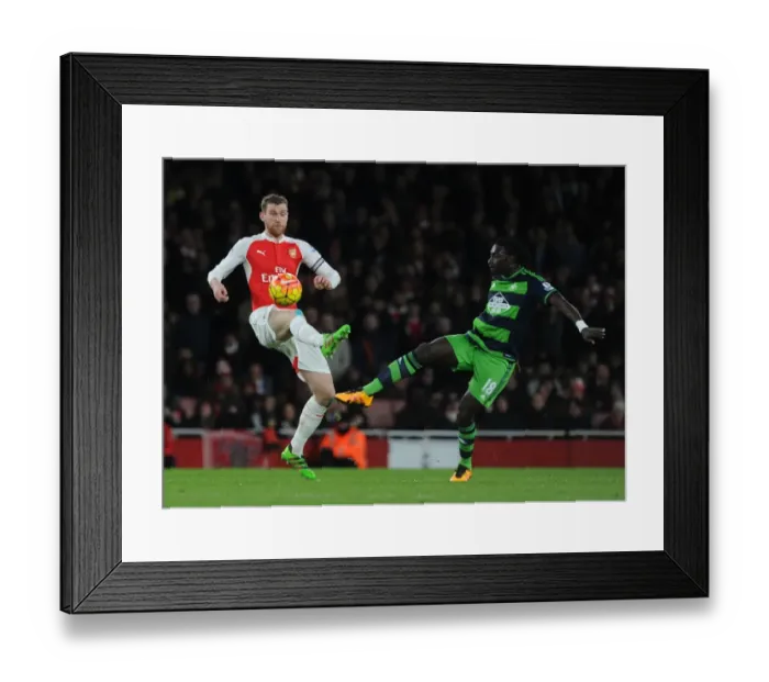 Framed Print : Arsenal vs Swansea Clash: Mertesacker vs Gomis Battle at Emirates Stadium Framed Print : Arsenal vs Swansea Clash: Mertesacker vs Gomis Battle at Emirates Stadium