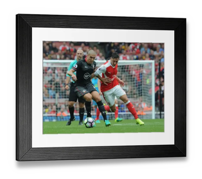 Framed Print : Ozil vs. Romeu: Intense Face-Off in Arsenal's Battle Against Southampton Framed Print : Ozil vs. Romeu: Intense Face-Off in Arsenal's Battle Against Southampton