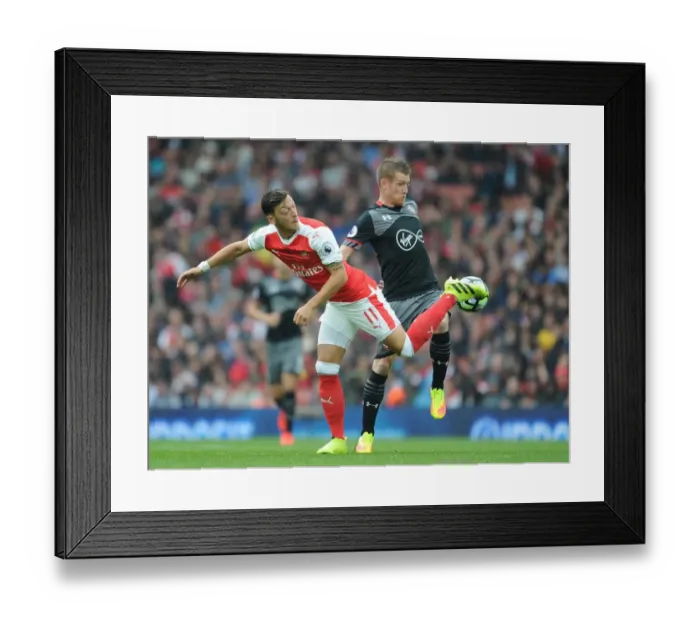Framed Print : Mesut Ozil vs Steven Davis: A Battle in the Arsenal vs Southampton Rivalry